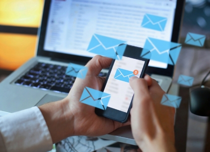 Man holding mobile phone with email campaign displayed