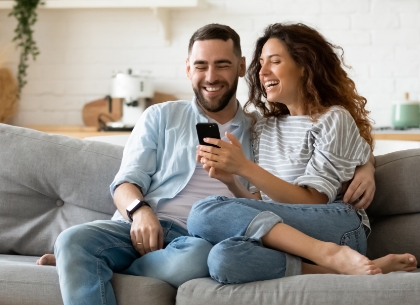 Couple on couch looking at mobile phone